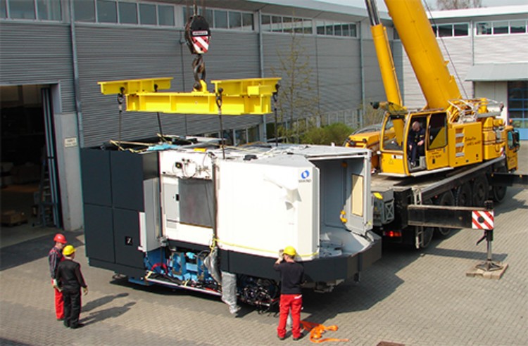 Mobile crane lifting a machine outside a factory
