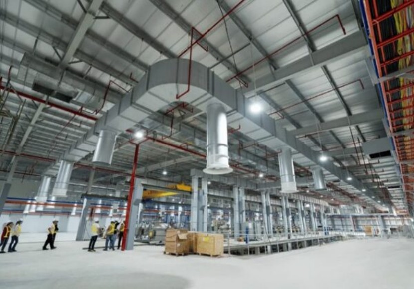 Factory hall with overhead ductwork, piping and production equipment