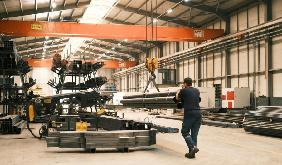 Overhead crane moving steel inside a pre-engineered industrial hall